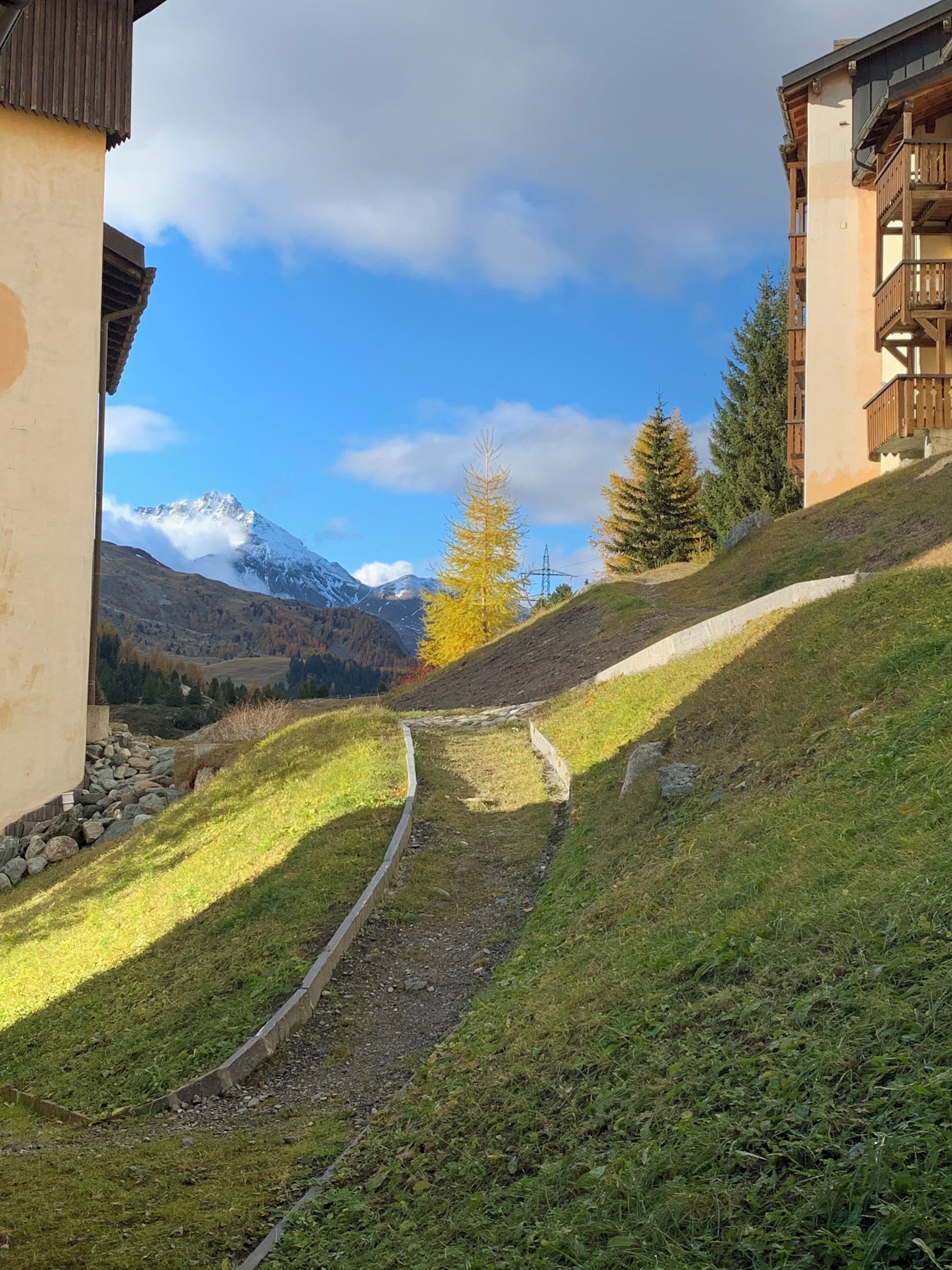 Un sentier menant à un bâtiment d’où l’on a vue sur la montagne.