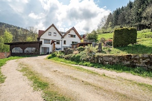 Ein zweistöckiges Haus mit einer Schotterauffahrt, die zu einem Holztor führt.