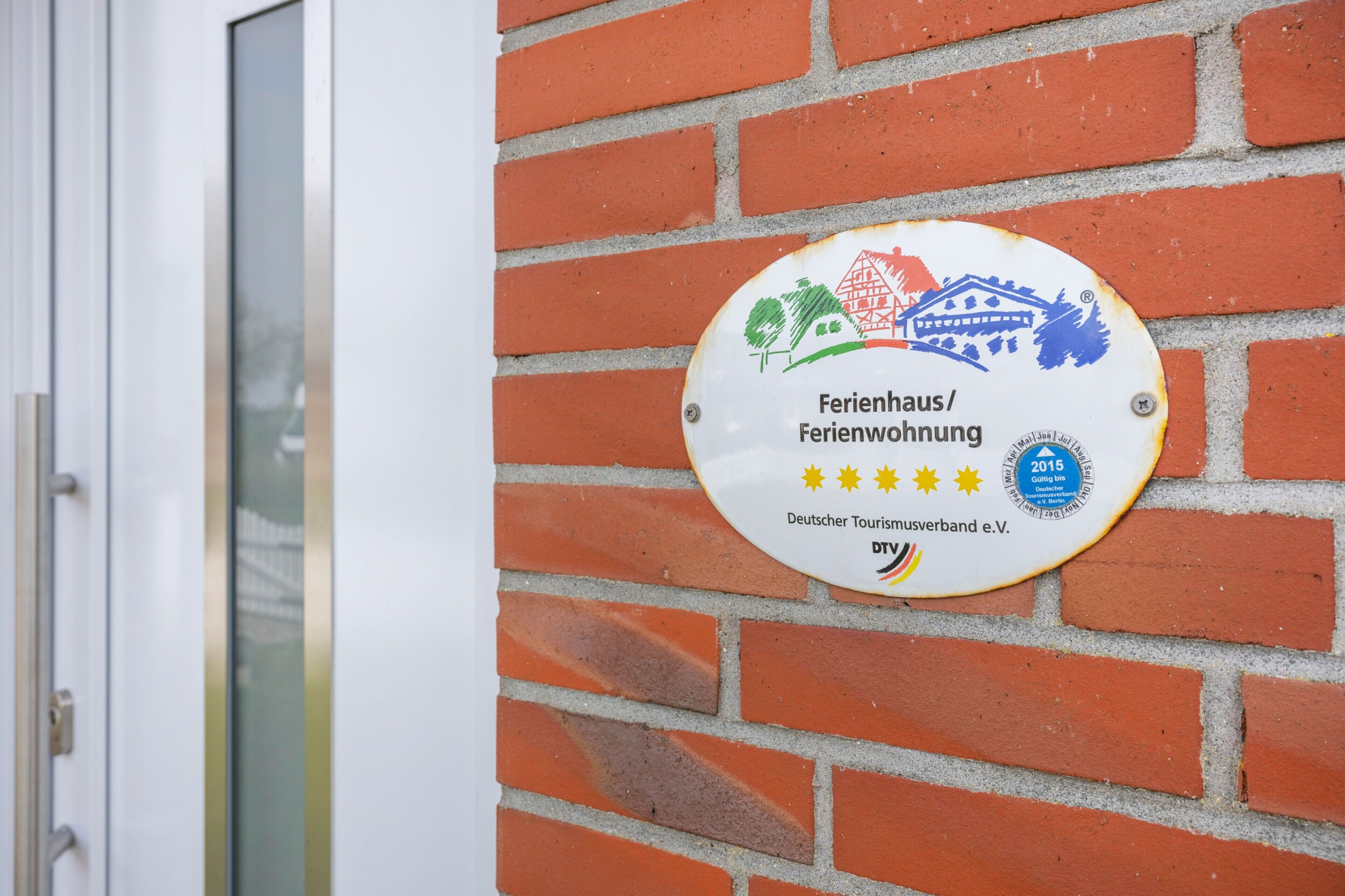 A plaque on a brick wall with text and a logo.