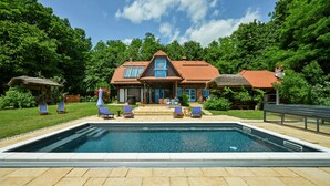Ein Haus mit Swimmingpool, Terrasse und Garten.