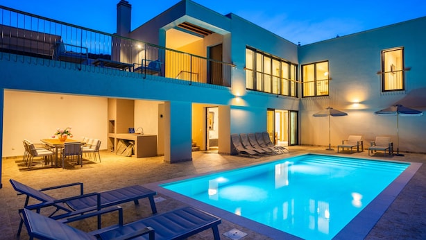 A modern two-story building with a swimming pool, outdoor seating, and a balcony. - Vila il Giardino Segreto with pool by Villas Guide (Matulji)