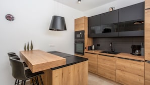 A modern kitchen with a wooden island, black countertop, and black cabinets. - Vila il Giardino Segreto with pool by Villas Guide (Matulji)
