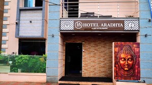 The exterior of Hotel Aradhya, a unit of Pilr Resort, featuring a prominent Buddha mural and a brick facade. - DhamStay Hotel Aradhya Near Beach Puri  (Puri)