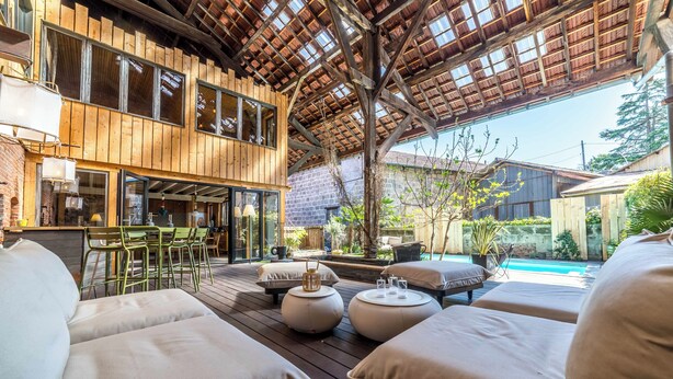A wooden deck with outdoor seating, a pool, and a bar area. - Exceptional urban loft with swimming pool: the ideal address for a dream vacation. (Brive-la-Gaillarde)