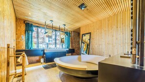 A modern bathroom with a wooden ceiling, a large bathtub, and a mirror. - Exceptional urban loft with swimming pool: the ideal address for a dream vacation. (Brive-la-Gaillarde)