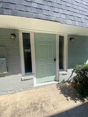 A house with a grey brick exterior, a white door, and a small porch area. - Private 1 Bedroom Apartment in Lawton near Fort Sill (Lawton)