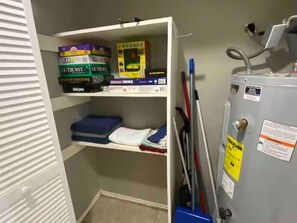 A storage closet with shelves containing boxes labeled 'OUTBURST' and 'FROGGER'. - Private 1 Bedroom Apartment in Lawton near Fort Sill (Lawton)