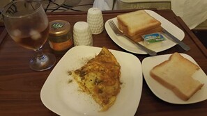 Un tavolo con un piatto di cibo, un bicchiere, saliera e pepiera, e una forchetta e un coltello.