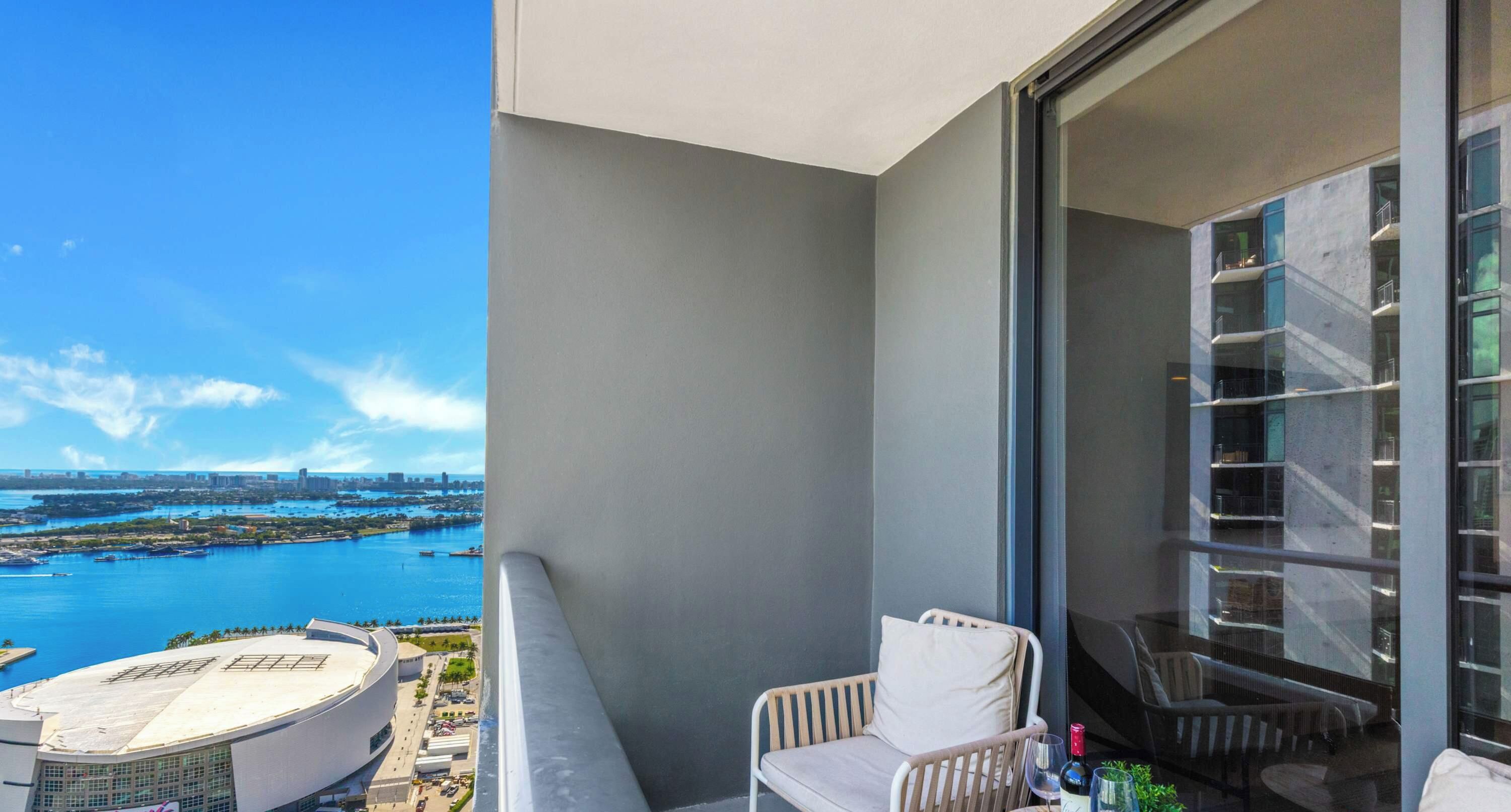 A balcony with a view of a marina and a modern building.