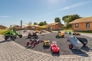 A playground with various toy vehicles and a sandy play area. - Vacation home "Huus Uul" in Kating for up to 6 people (Kating)