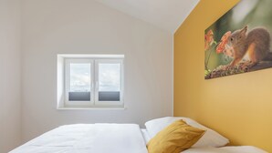 Une chambre à coucher avec un lit, une fenêtre et un tableau représentant un écureuil.