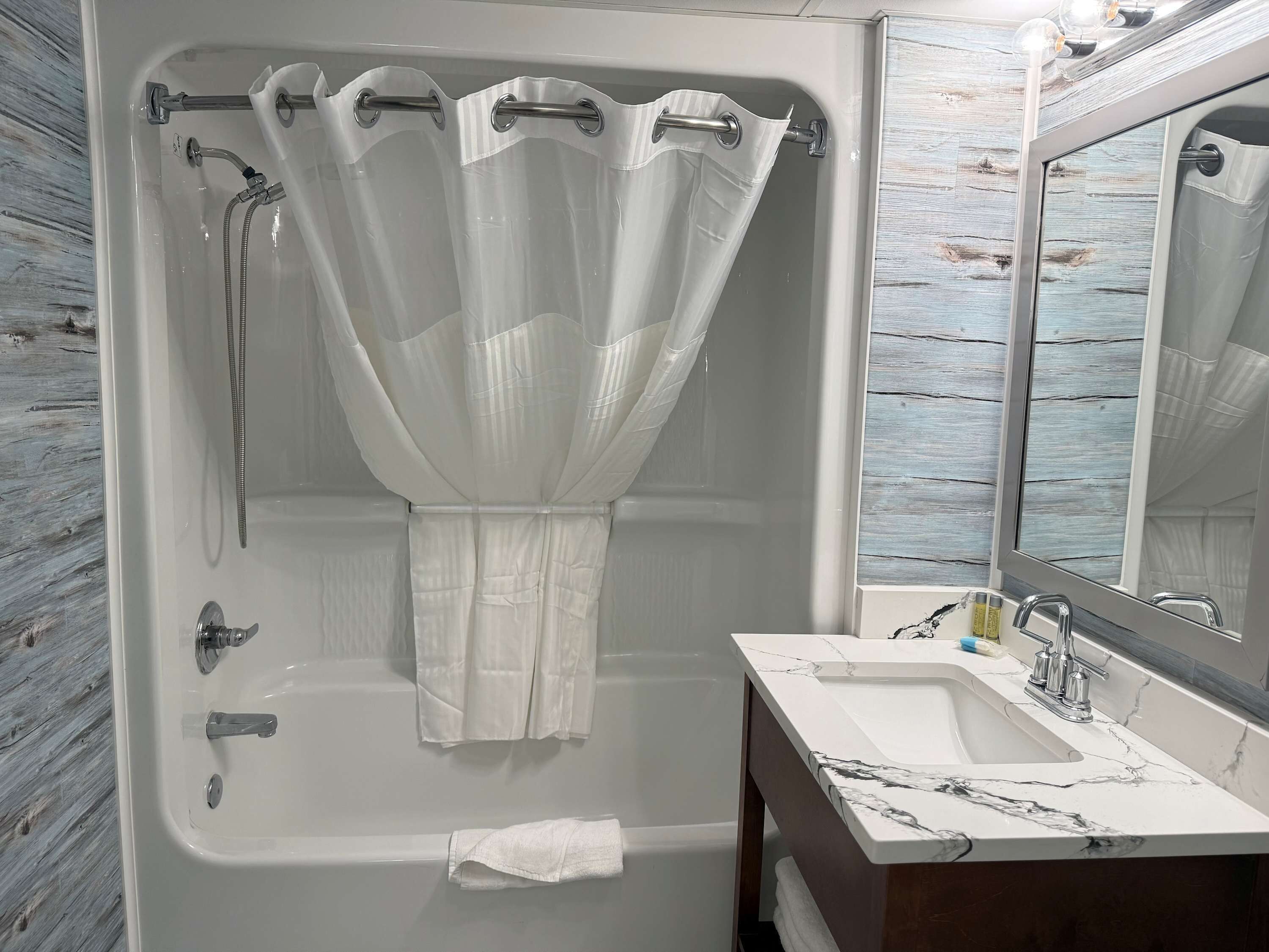 A bathroom with a bathtub, shower, and sink.