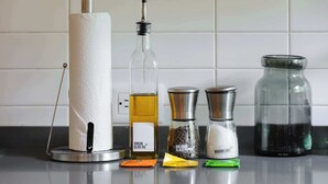 A kitchen counter with a paper towel holder, a bottle of virgin olive oil, a bottle of black pepper, a salt shaker, and a jar of water. - w* | Radiant 2BR in Roma Norte (Ciudad de México)
