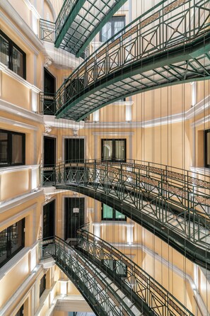 A multi-level interior with ornate railings and a reflective floor.