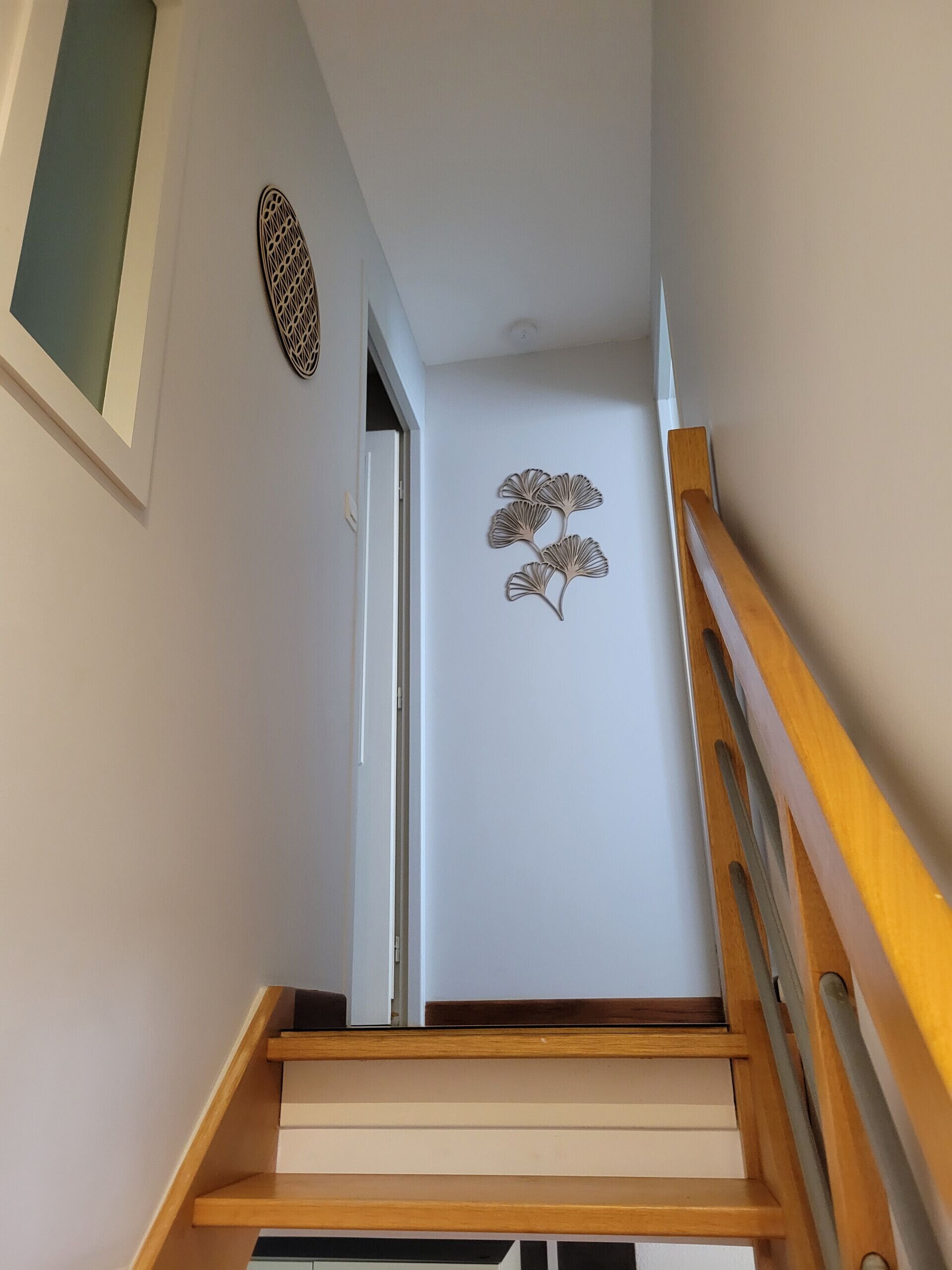A staircase with wooden handrails and a wall-mounted decorative piece.