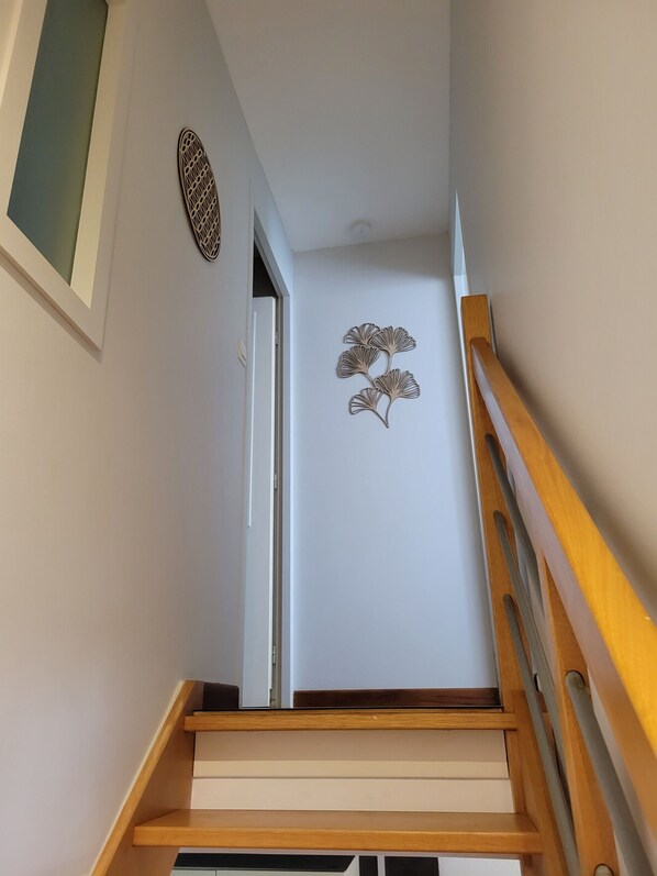 A staircase with wooden handrails and a wall-mounted decorative piece.