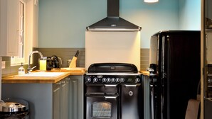 A kitchen with a stove, oven, and refrigerator.