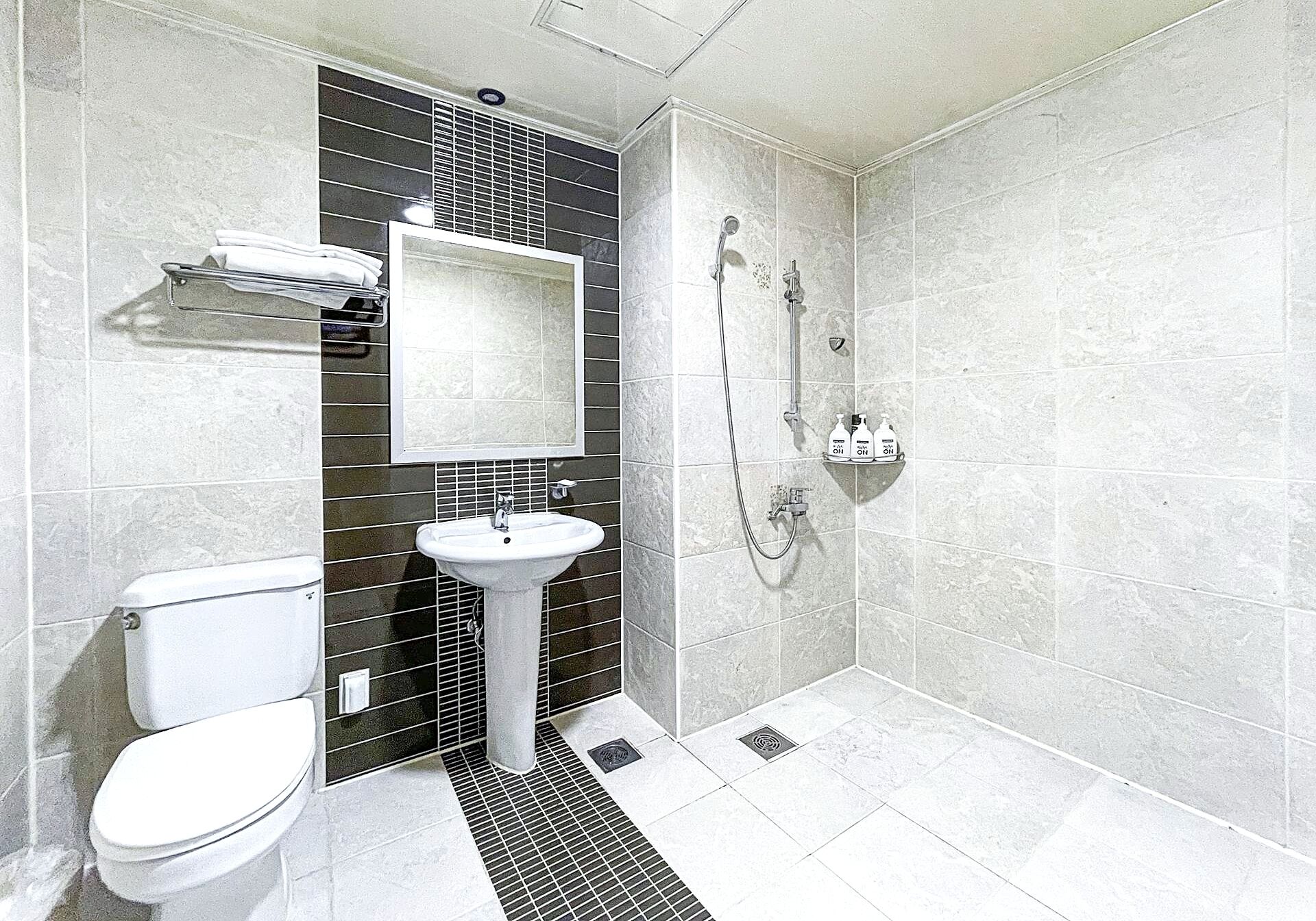 A bathroom with a toilet, sink, and shower.