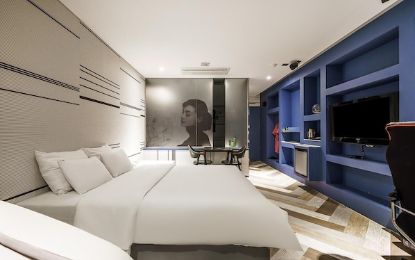 A modern bedroom with a large bed, a desk, and a TV. - HOTEL ON (Uiwang)