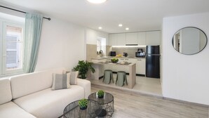 Un apartamento moderno con sala de estar, kitchenette y comedor.