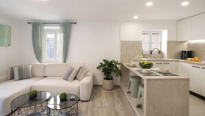 Una sala de estar moderna con un sofá, una mesa de centro y una planta en maceta.