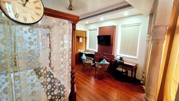 A dining area with a wooden table, chairs, and a television mounted on the wall.
