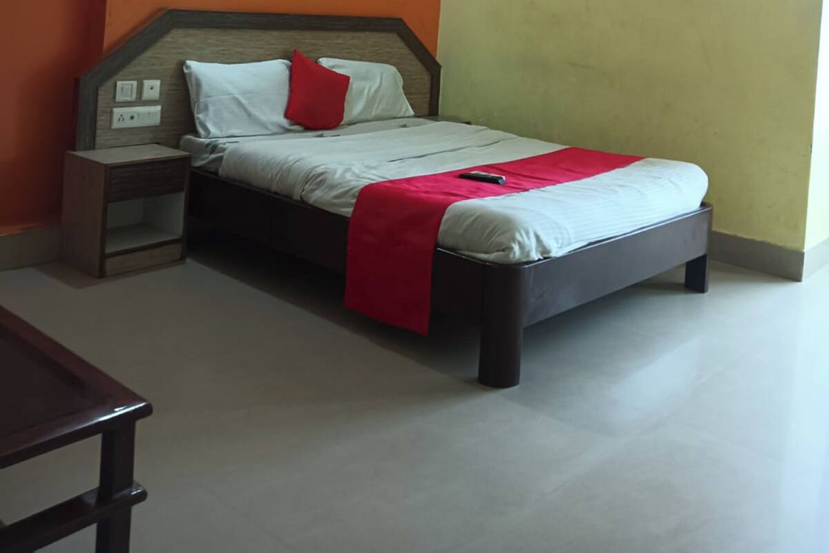 Un dormitorio con cama, mesita de noche y ventilador de techo.