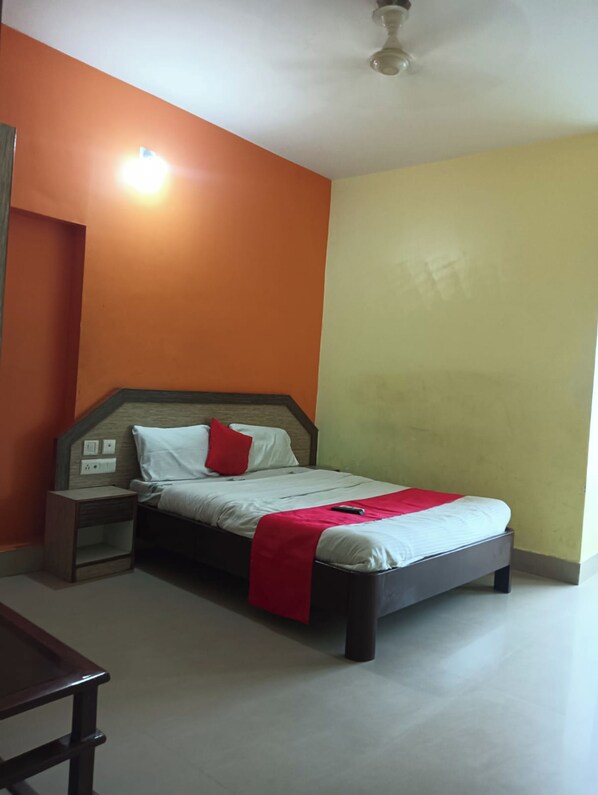 A bedroom with a bed, nightstand, and a ceiling fan.