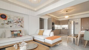 A modern living room with a sofa, coffee table, and a dining area with a table and chairs.