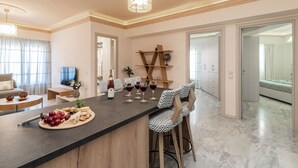 A modern kitchen with a bar area, featuring a marble countertop, bar stools, and a wine rack. - ExAnimo Luxury Apt 5 (Zakinthos)