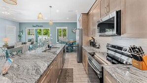 A modern kitchen with granite countertops, stainless steel appliances, and wooden cabinets.