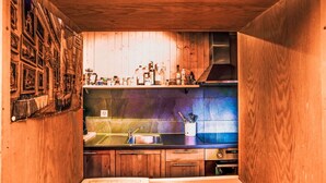 A compact kitchen with wooden cabinetry, a stainless steel sink, and various kitchen appliances. - Beautiful private villa for 6 guests with WIFI, TV, terrace and panoramic view (Les Collons)