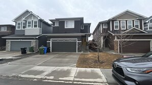 Eine Wohnstraße mit zwei Häusern, jeweils mit Garage und Auffahrt.