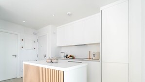 A modern kitchen with white cabinetry, a wooden countertop, and a built-in oven. - Casa Lozano - Sea View Apartment with Terrace and Pool, Higueron West, Fuengirola (Fuengirola)