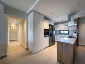 A modern kitchen with a central island, built-in appliances, and a view to the living area. - 4 Bedroom Beach Penthouse w private rooftop (Punta Cana)