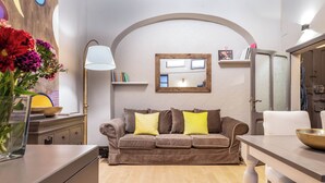 A cozy living room with a brown sofa, a white lamp, and a wooden ceiling.