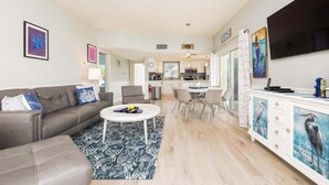 A modern living room with a grey sofa, a white coffee table, and a patterned rug. - Port Largo Villas Escape 5A (Key Largo)