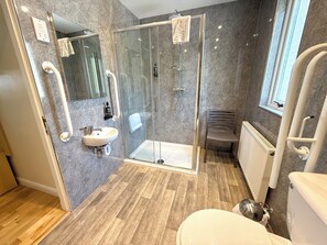 A modern bathroom with a glass-enclosed shower, a sink, and a toilet. - Seabank House Hotel (Nairn)