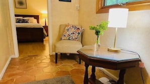 A hotel room with a bed, a chair, a small table with a lamp, and a window. - Quiet Retreat for longer term bookings- Downstairs apartment 5 miles to FSU (Tallahassee)