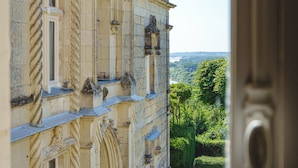 A historic building with ornate architectural details, a stone facade, and a view of the surrounding landscape. - Castle near Saumur with stunning Loire view, large nature chateau with tennis (Gennes-Val-de-Loire)