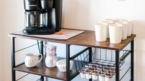 Een keukentrap met een koffiezetapparaat, een muggenhouder en een plank met keukenspullen.