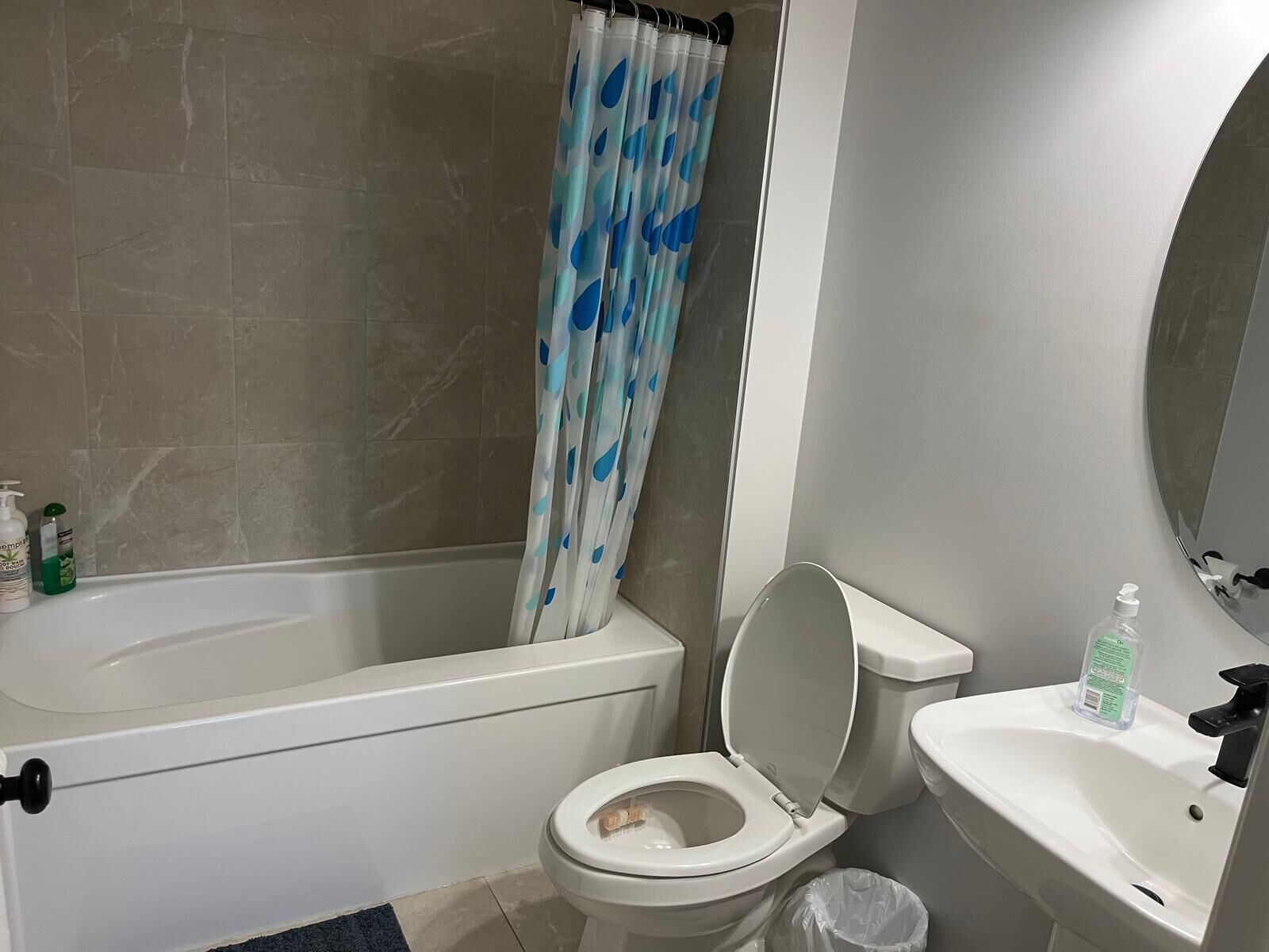 Een badkamer met een bad, toilet, wastafel en douchegordijn.