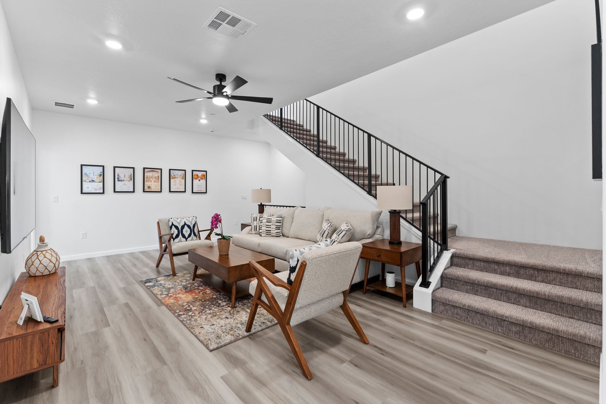 A spacious living room with a sofa, coffee table, and a staircase.