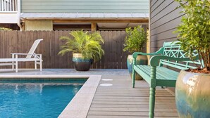 A wooden deck with a pool, a green bench, and potted plants. - Newly Built Lux Grayton Beach Home "Timeless 30A" Pool, Golf Cart, Bikes (Santa Rosa Beach)