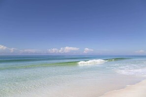 A beach with clear water and a sandy shore.