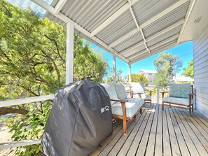 Relax in an outdoor space with lounge chairs and a barbecue grill.