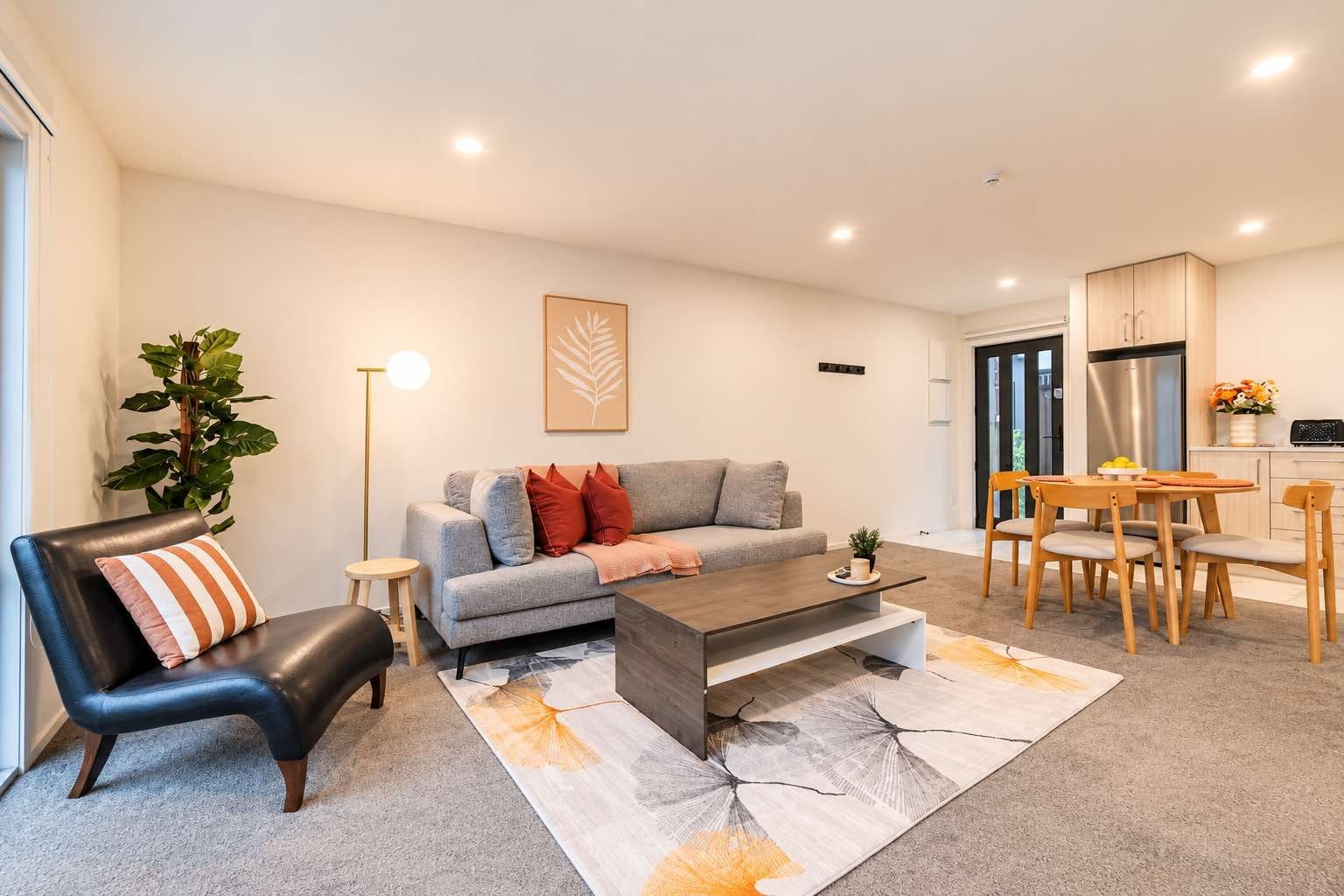 A modern living room with a sofa, coffee table, and dining area.