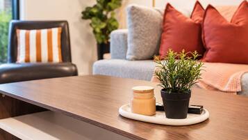 Una mesa de madera con una planta en maceta y una vela sobre una bandeja.