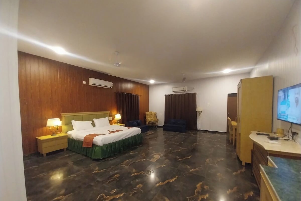 Une chambre d’hôtel équipée d’un lit, d’un bureau, d’une télévision et d’une armoire.