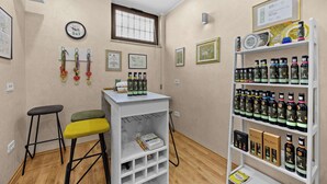 Una habitación con una zona de bar blanca, taburetes, una estantería con diplomas enmarcados y un reloj en la pared.